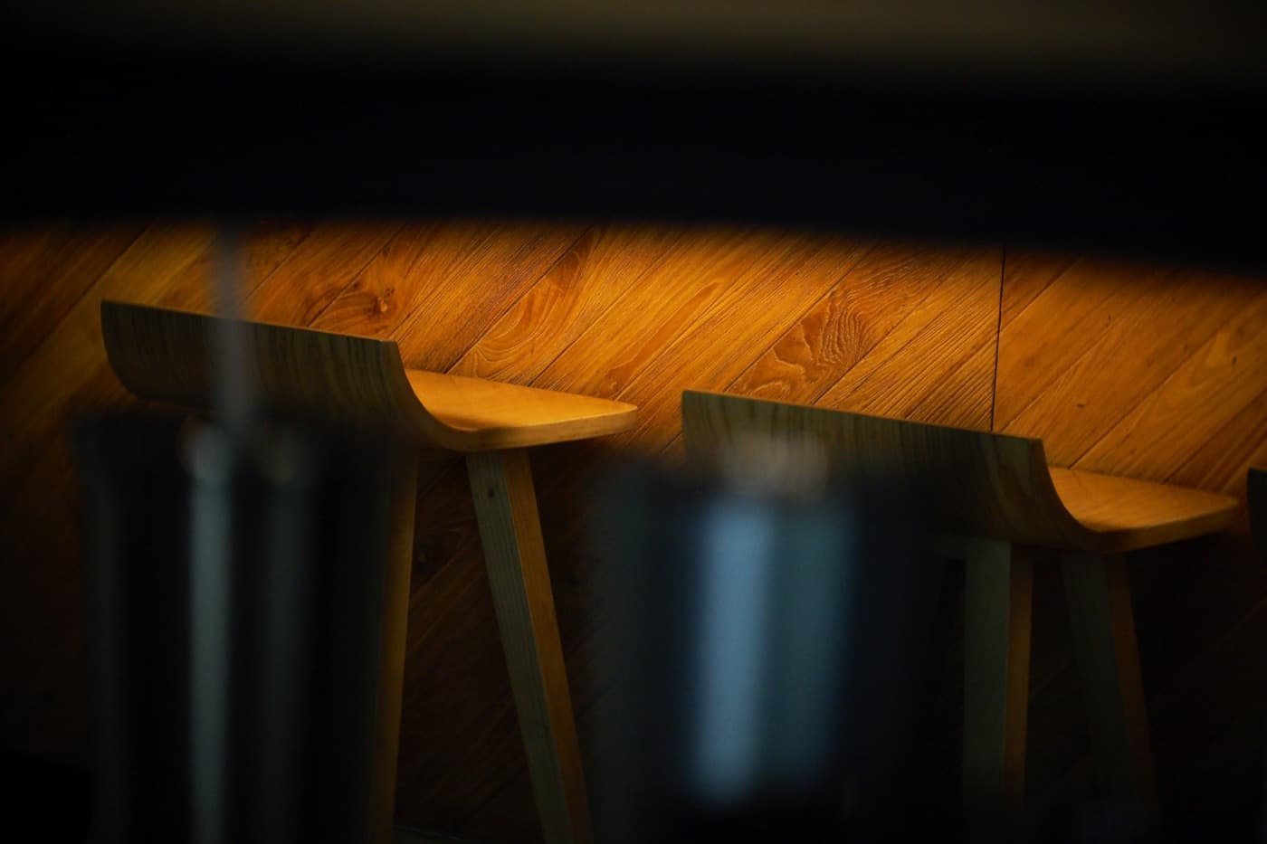 Wooden stools along a bar on a wooden floor